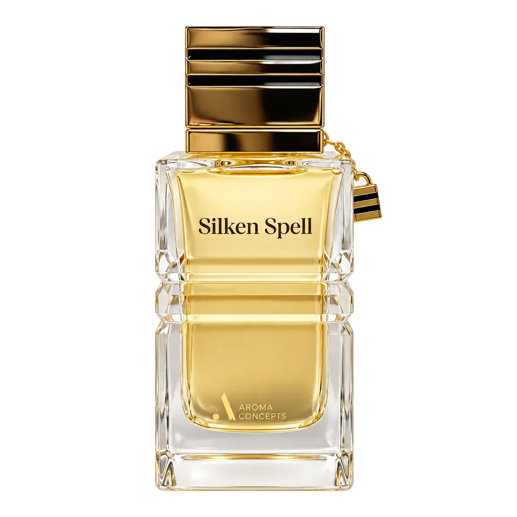 A clear glass perfume bottle labeled 'Silken Spell' with a reflective gold cap, shown with two small clear sample spray vials on a plain white background.