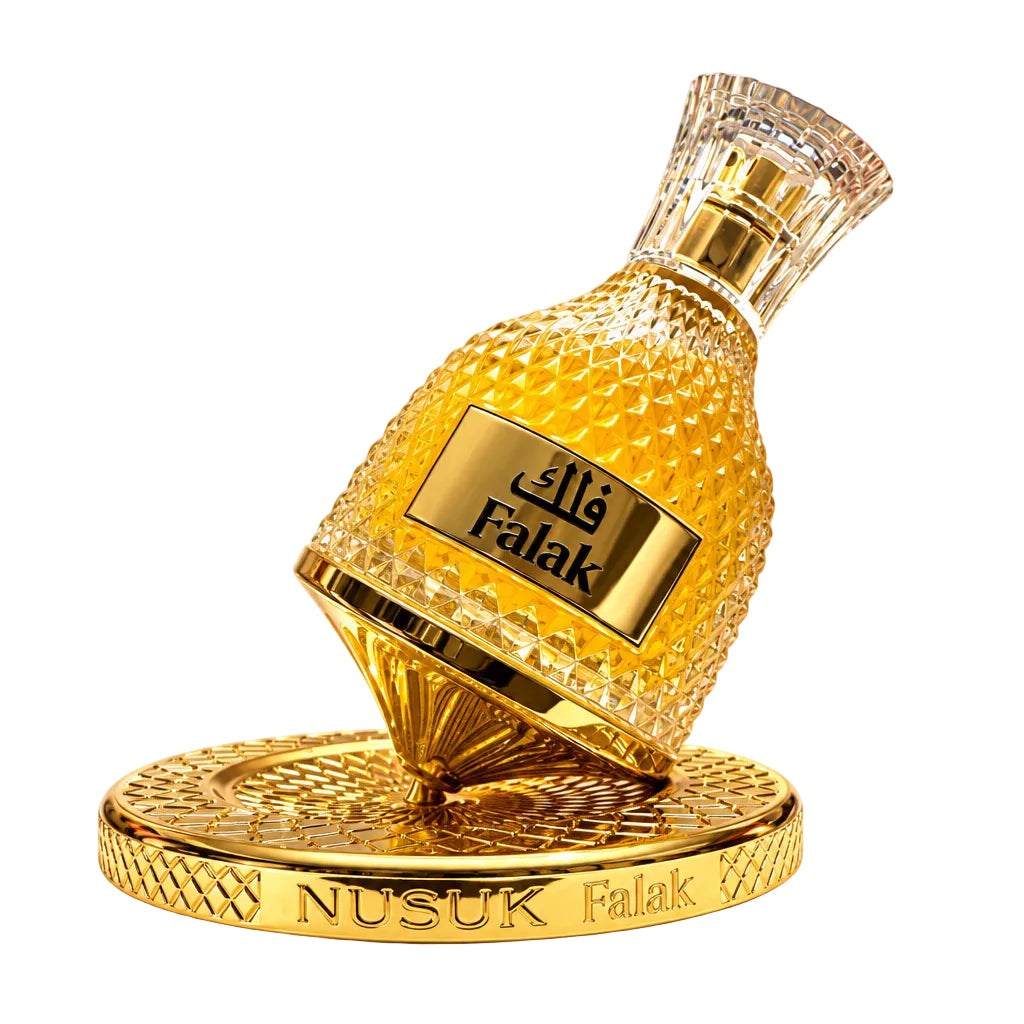 A gold-colored textured perfume bottle labeled 'FALAK NUSUK' resting on a matching gold base, with two small clear sample spray vials beside it, all on a plain white background.